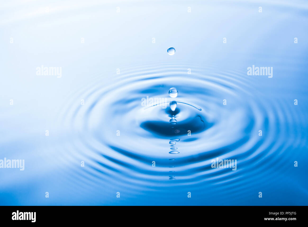 Acqua goccia caduta in acqua fare le onde. Spruzzi di acqua o acqua goccia sfondo. Foto Stock