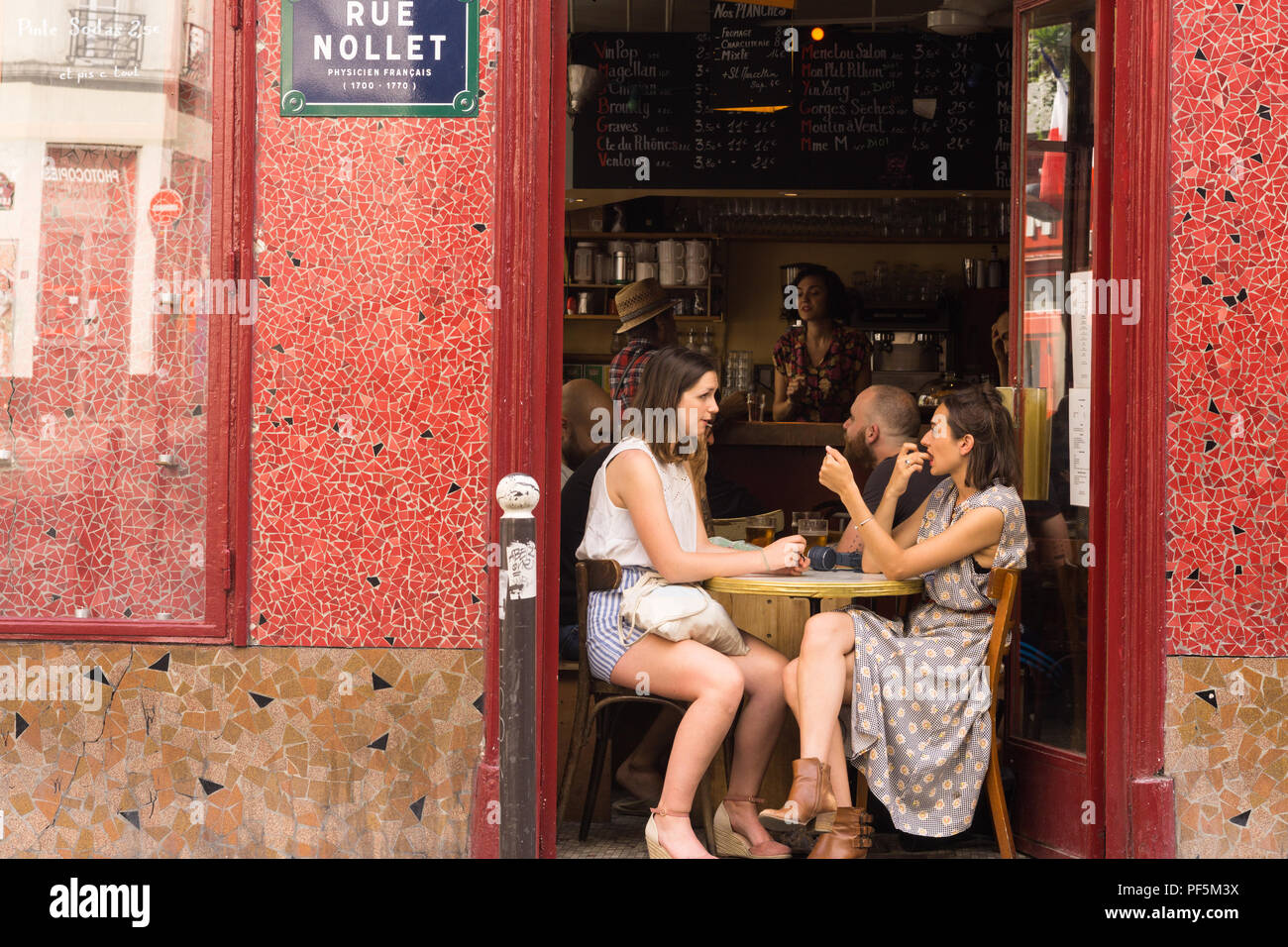 Due ragazze di Parigi chat a Les Caves Populaires bar nella zona di Batignolles, xvii arrondissment. In Francia, in Europa. Foto Stock