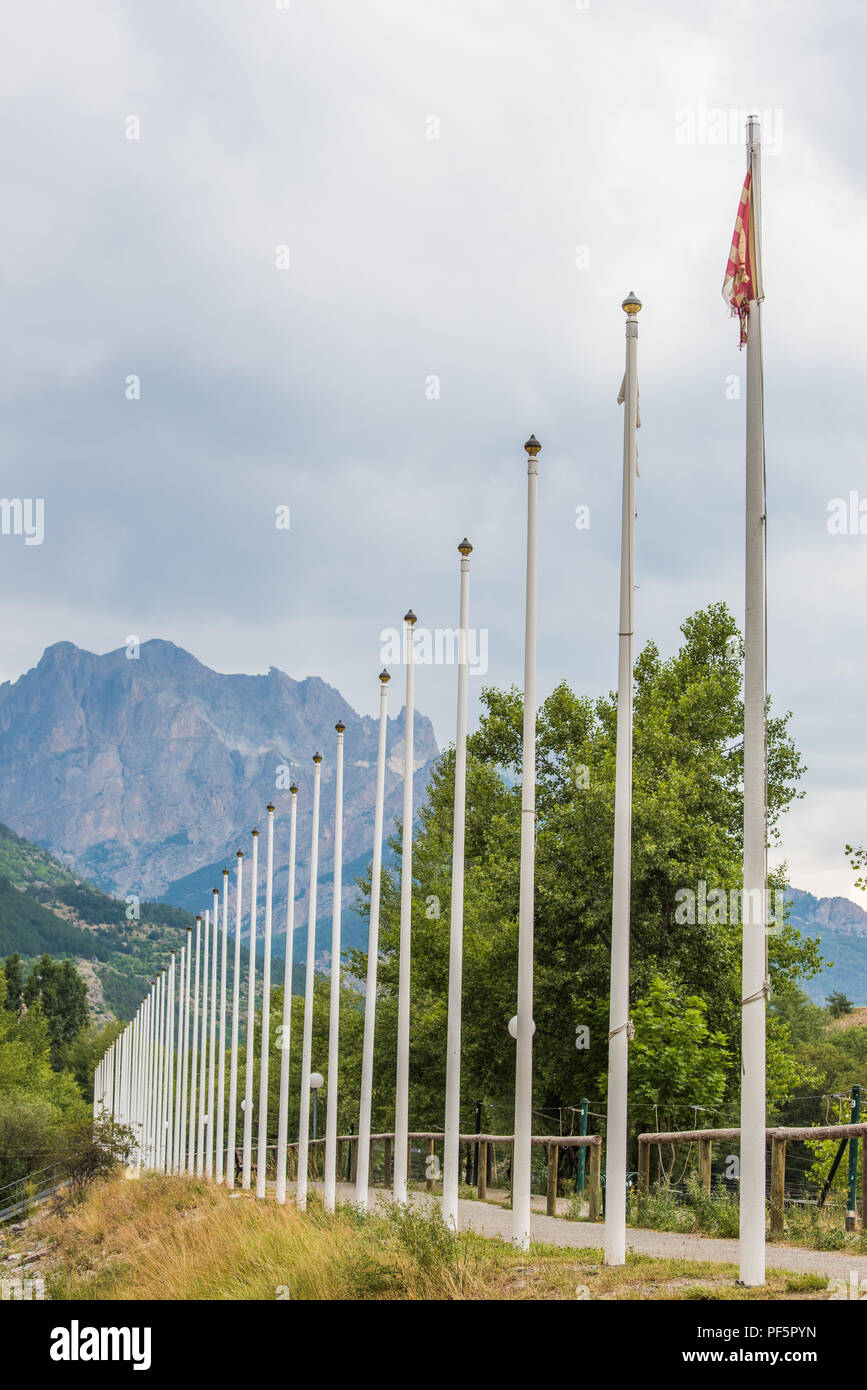 Poli accanto lo slalom di corso presso il villaggio di L'Argentierre la Bessee, Hautes Alpes, Francia, con la montagna le venelles in background. Foto Stock