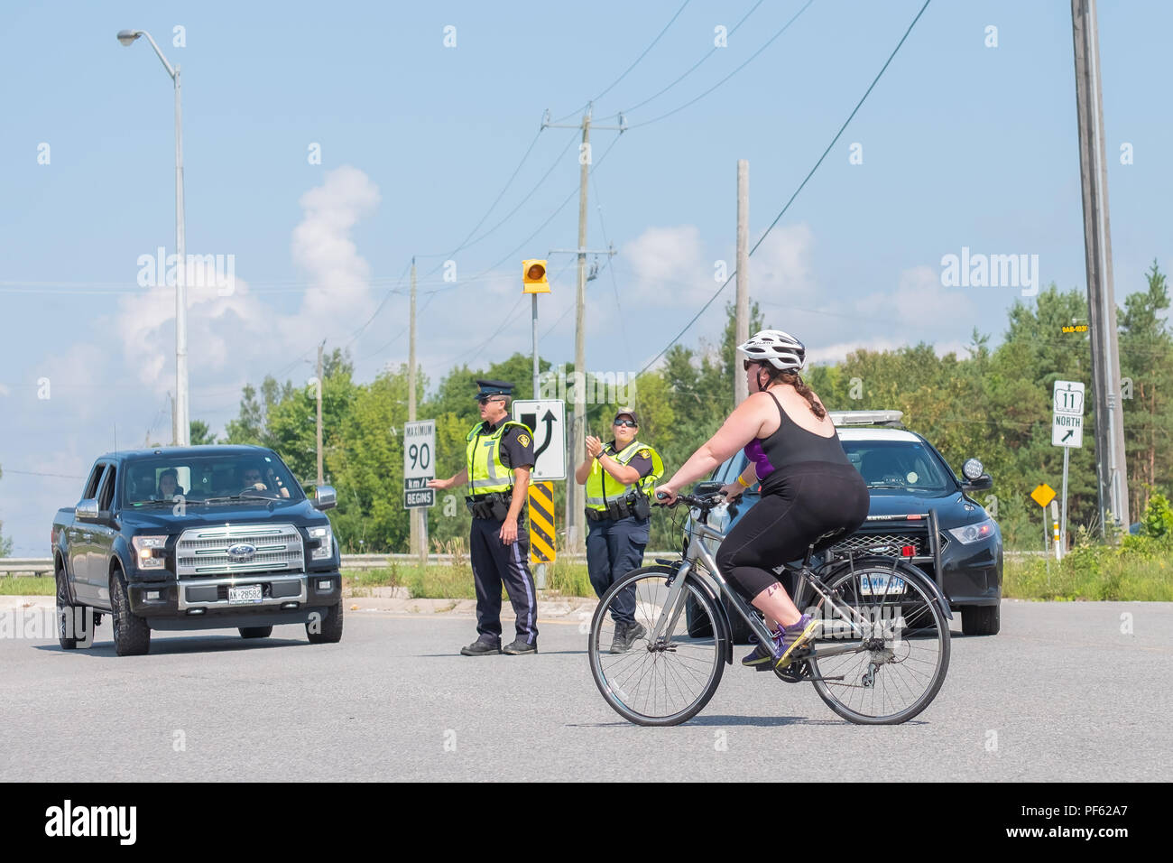 Femmina adulta compete nel ciclismo gamba del Triathlon Orillia, una manifestazione popolare con le gare per tutte le età e i livelli di specialità. Foto Stock