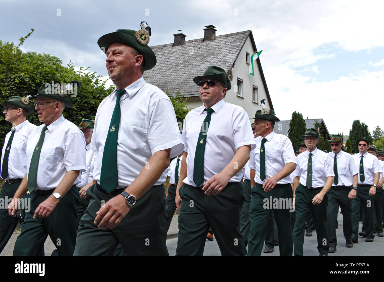 Usseln, Germania - Luglio 30th, 2018 - fucile i membri del club che sfilano in loro tradizionale di colore bianco e verde di uniformi alla tiratori giusto Foto Stock