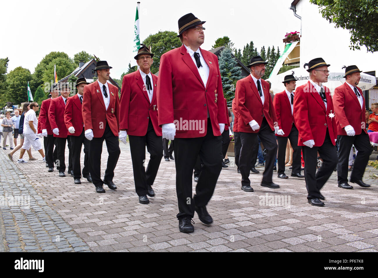 Usseln, Germania - Luglio 29th, 2018 - fucile i membri del club che sfilano in loro tradizionale divisa rossa alla tiratori giusto Foto Stock