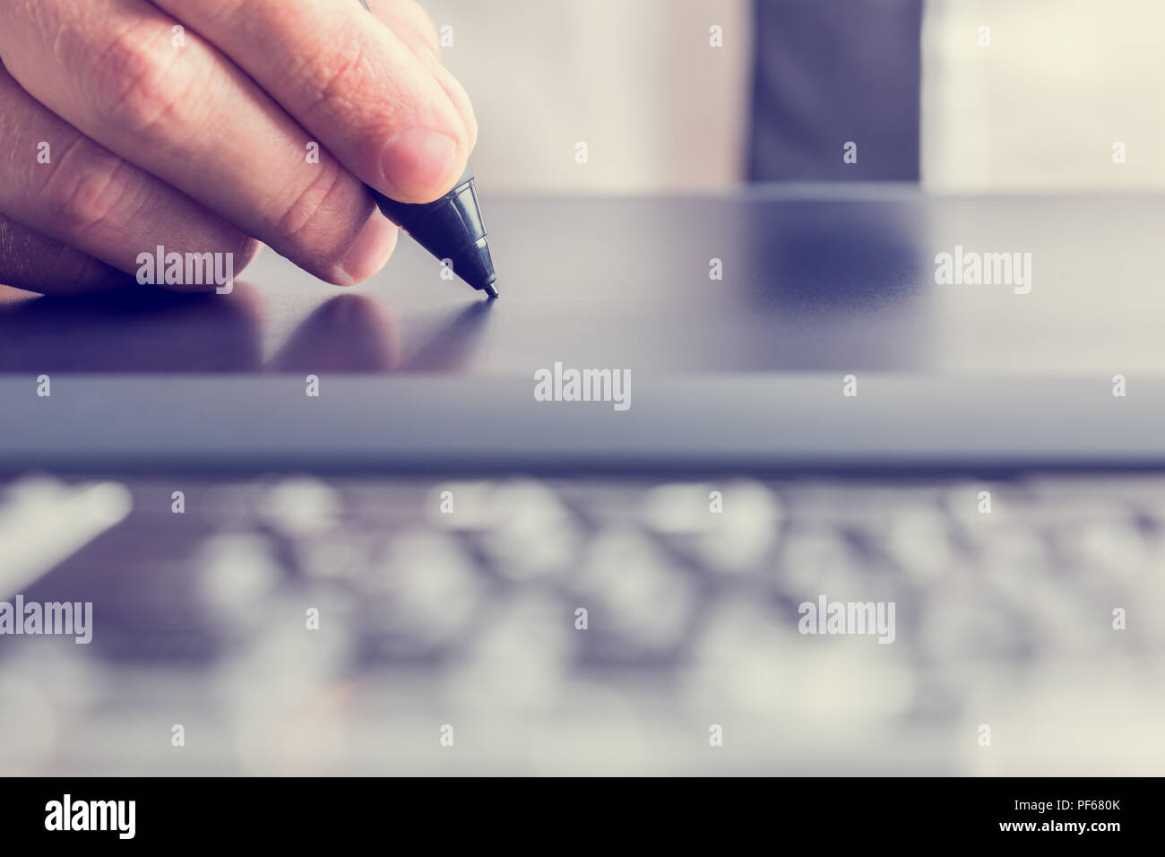 Immagine retrò dei maschi di mano di un designer di disegno con lo stilo sul grigio di una tavoletta grafica, close-up. Foto Stock