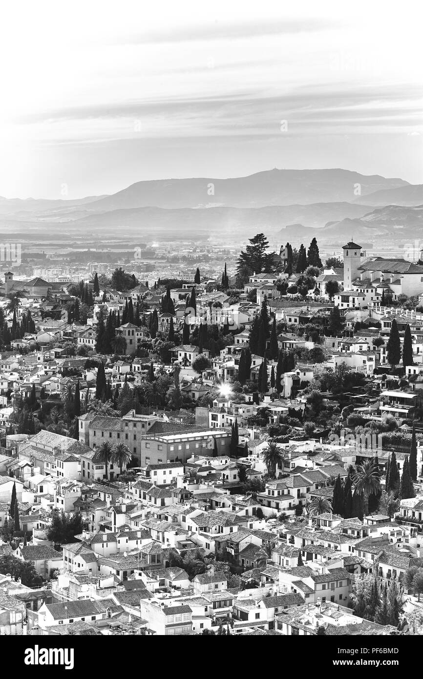Visualizzazione bianco e nero sui tetti della città spagnola Granada in Andalusia con le montagne sullo sfondo Foto Stock