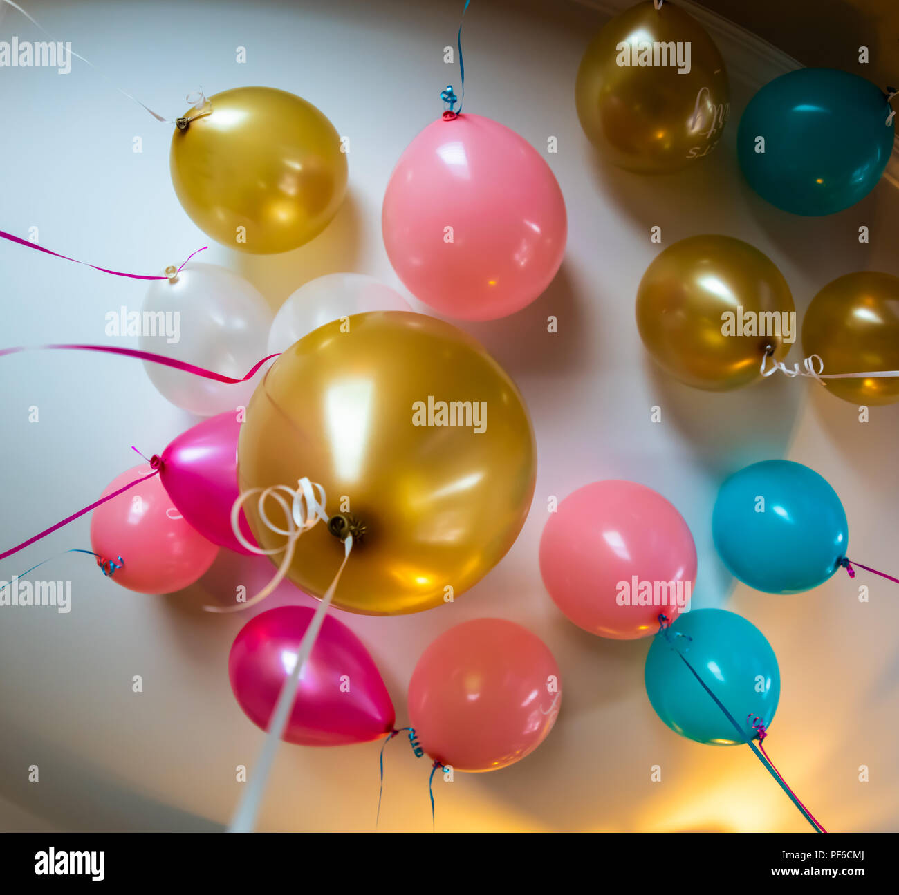 Un grappolo di palloncini da una celebrazione sono riempiti con elio e la  flottazione verso il soffitto Foto stock - Alamy