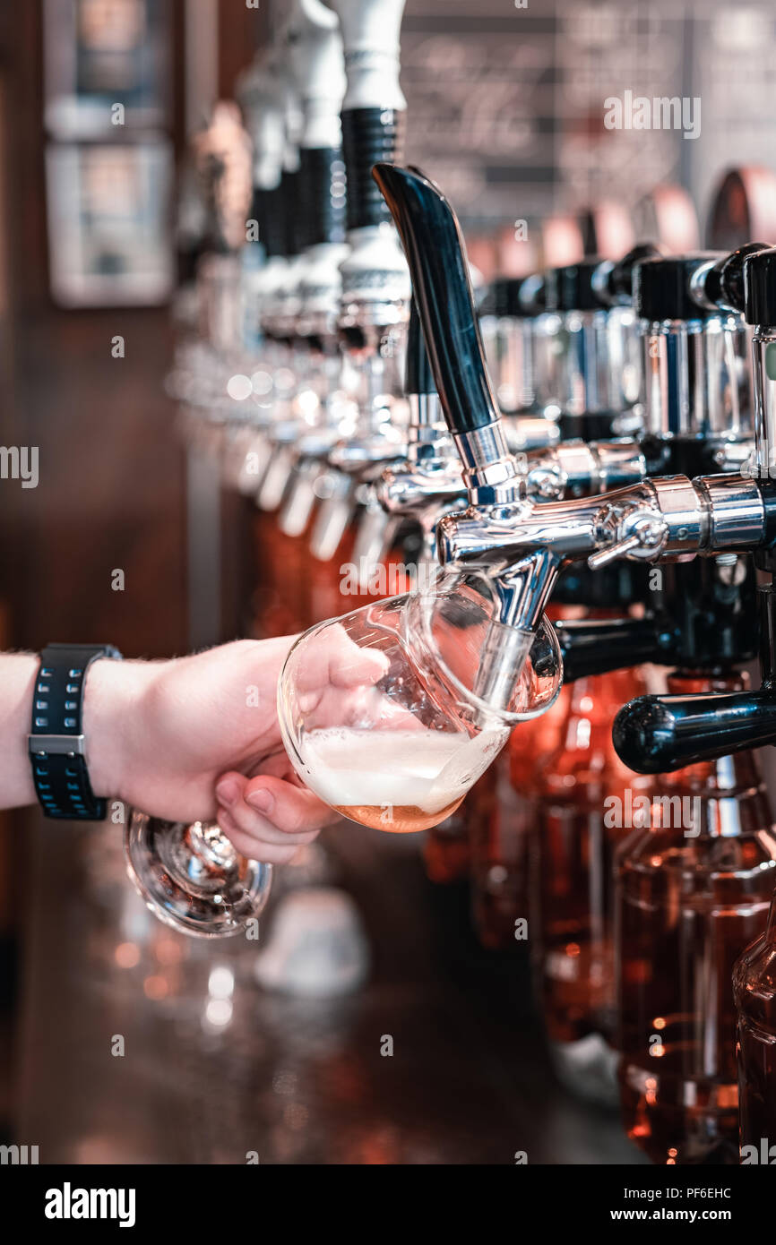 Barman versando qualche oscuro la birra artigianale in vetro Foto Stock