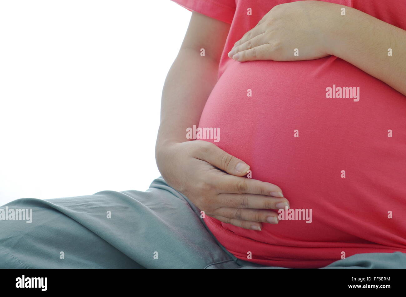 Donna incinta con piccolo grazioso baby all'interno caldo e tenere in mano mostra materno amore e cura con sfondo bianco Foto Stock
