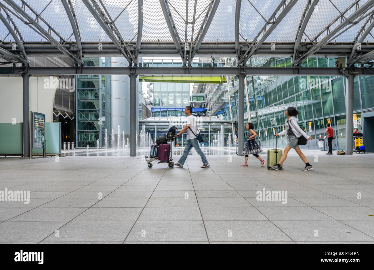 Persone che arrivano al London Heathrow Airport Terminal 5 edificio pre-pandemic (2018), Inghilterra, Regno Unito Foto Stock