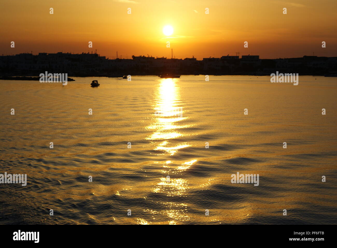 Grecia, l'isola di Paros. Il sole tramonta sulla vicina isola di Anti Paros Foto Stock