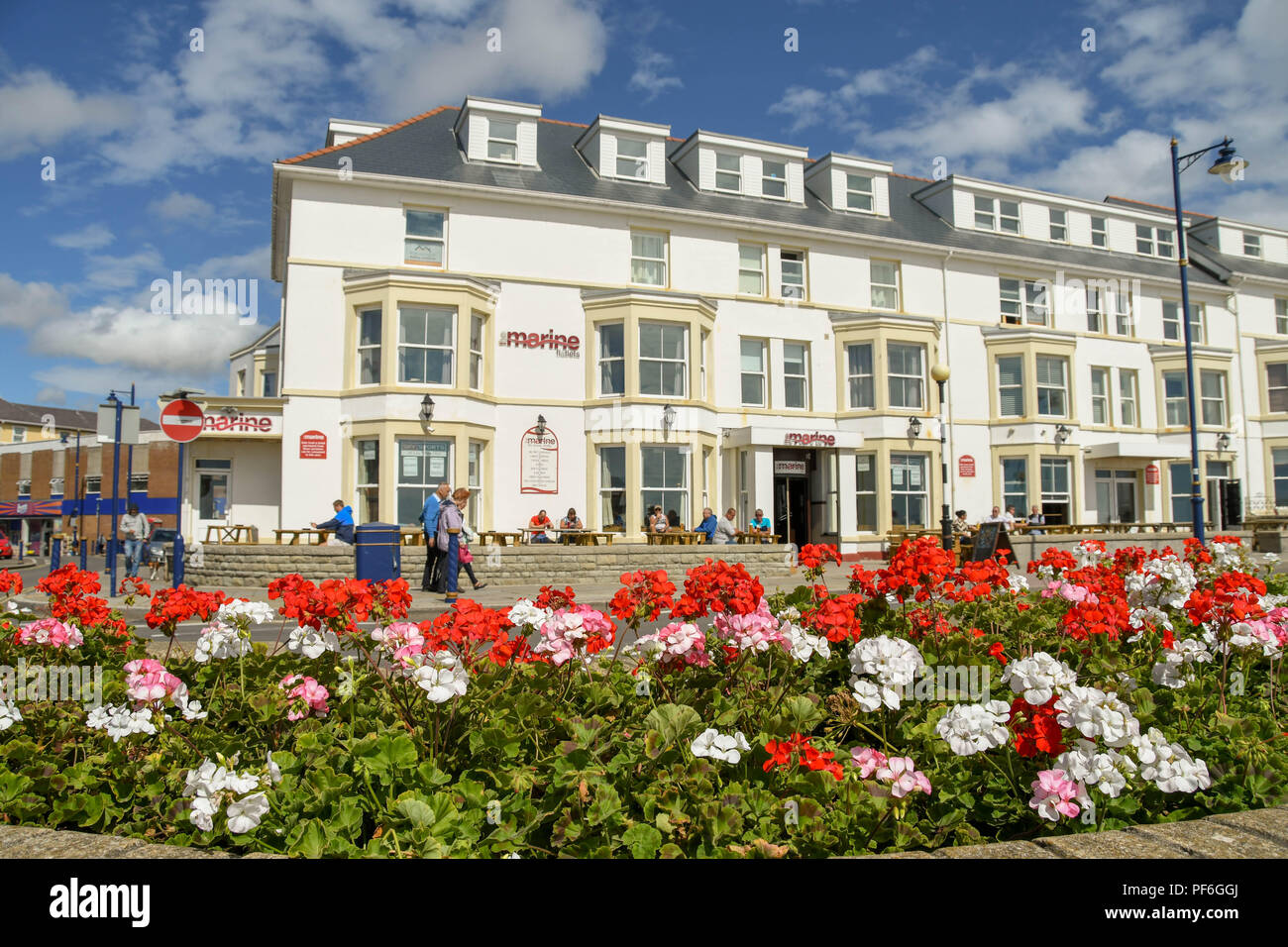 La Marina Appartamenti sul lungomare di Porthcawl, Galles. In primo piano è un letto floreale con fiori di colore rosso. Foto Stock