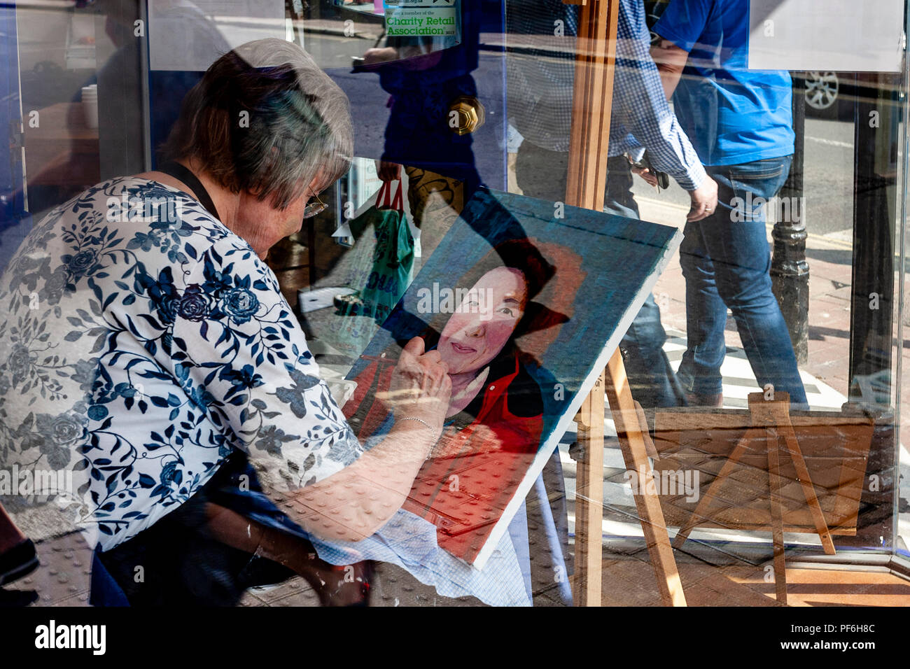 Un artista locale di verniciatura di un immagine in una finestra del negozio, Lewes, Sussex, Regno Unito Foto Stock