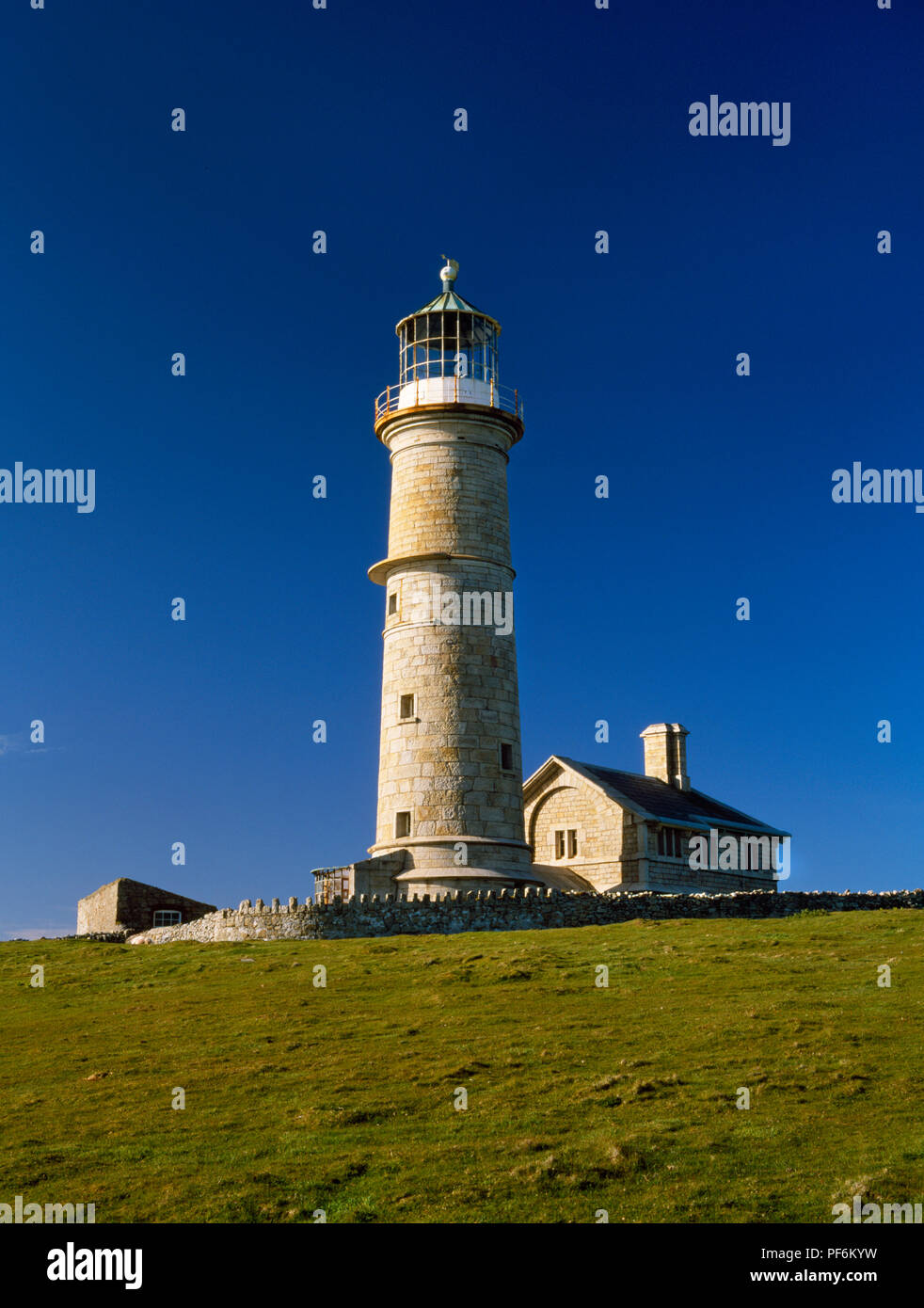 Il vecchio faro di luce, Lundy Island, Devon. Vista esterna verso nord est, nel tardo pomeriggio presso il faro torre rotonda e custodi della casa. Foto Stock