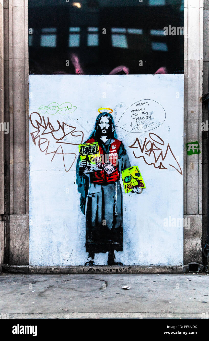 Un graffiti vandalizzato di Gesù che vende la rivista Big Issue, Londra, Inghilterra, Regno Unito. Foto Stock
