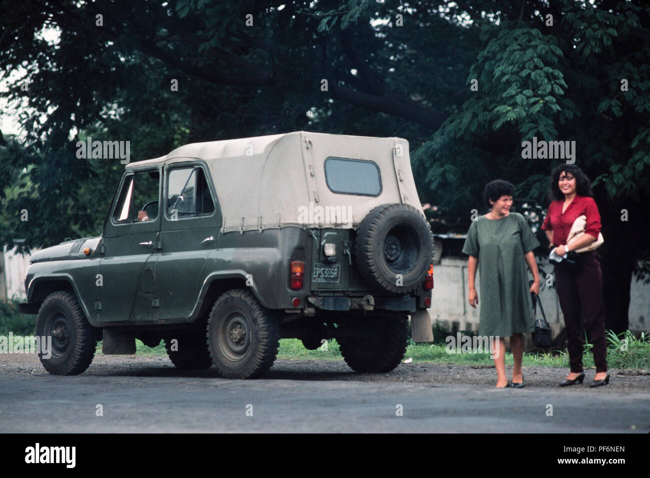 Managua, Nicaragua, giugno 1986; due donne cadere fuori sulla strada Masaya da Russo in dotazione esercito FSLN jeep. Foto Stock