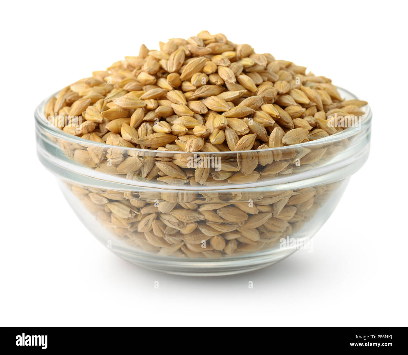 Ciotola di vetro di chicchi d'orzo isolato su bianco Foto Stock