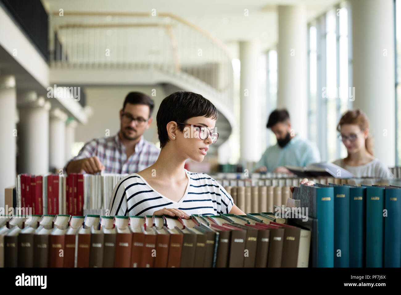 Donna felice presso la biblioteca Foto Stock