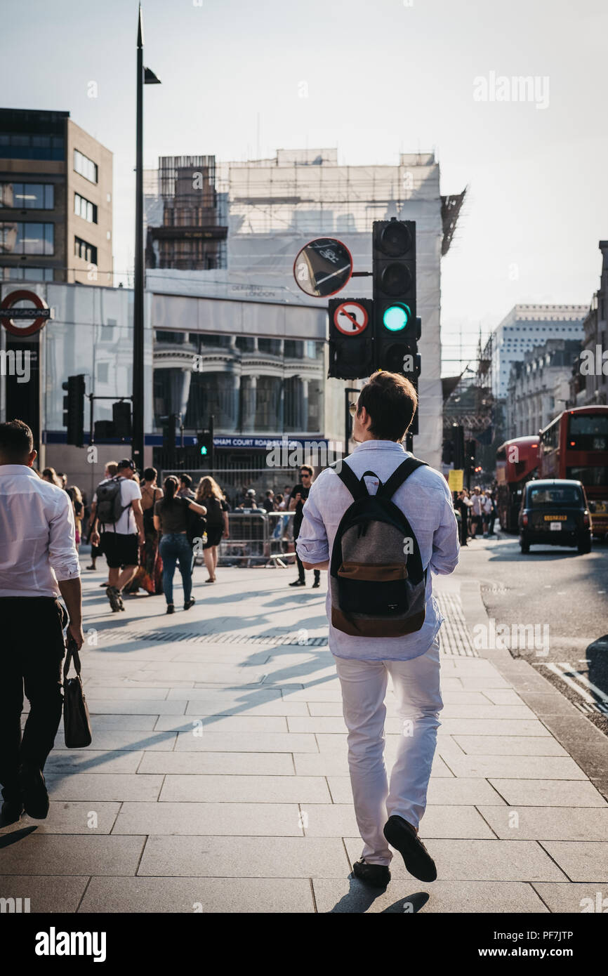 Le persone camminare vicino a Tottenham Court Road, Londra, al tramonto. Tottenham Court Road è una rete metropolitana di Londra e un futuro Elizabeth fermata della linea. Foto Stock
