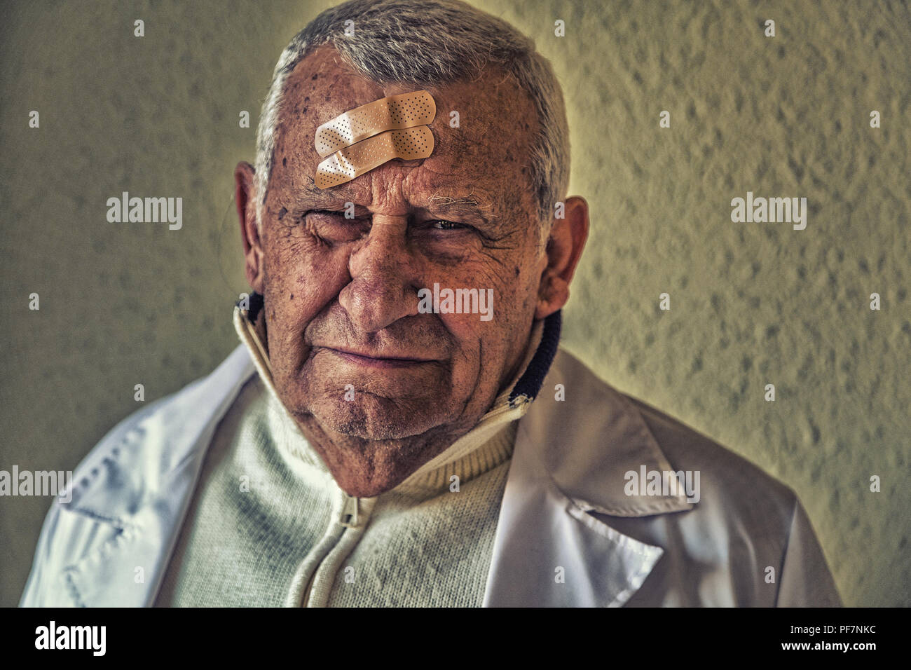 Il vecchio medico con patch sulla fronte Foto Stock