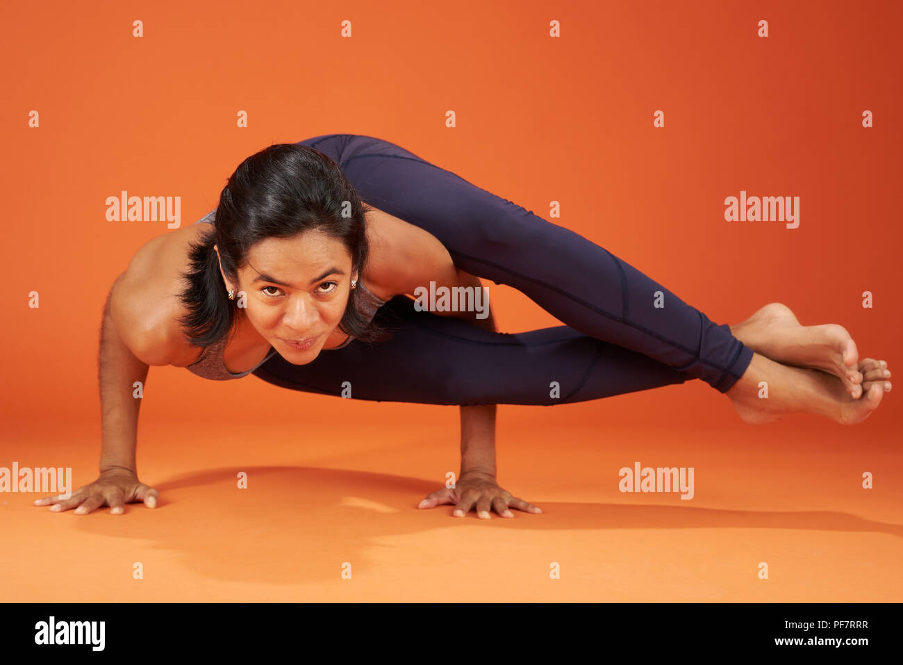 Eight-Angle yoga pone donna visualizza il colore arancione di sfondo per studio Foto Stock