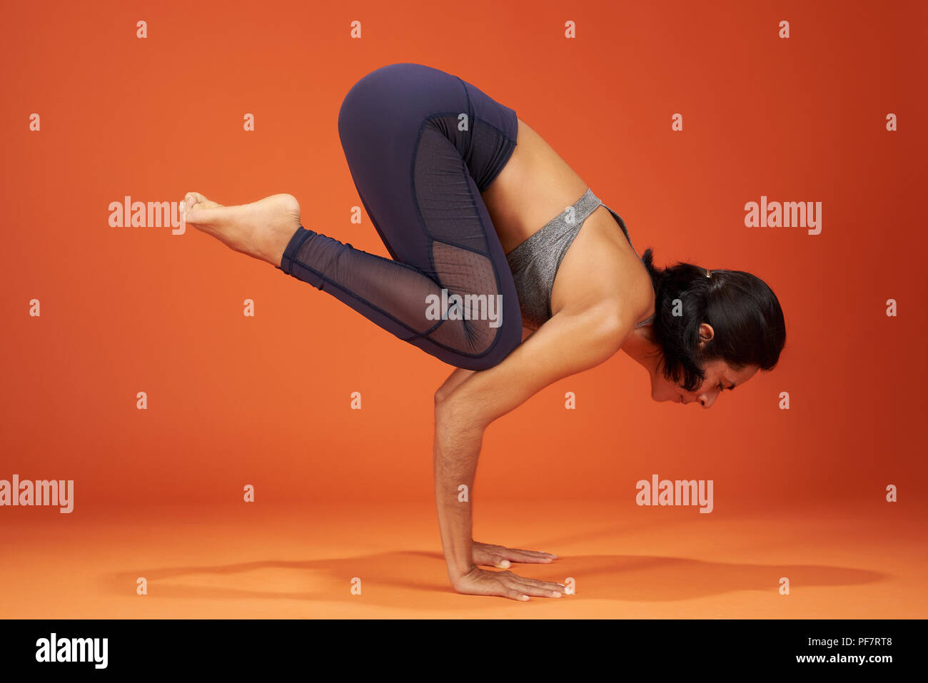 Gru yoga pone la donna mostra su sfondo per studio Foto Stock