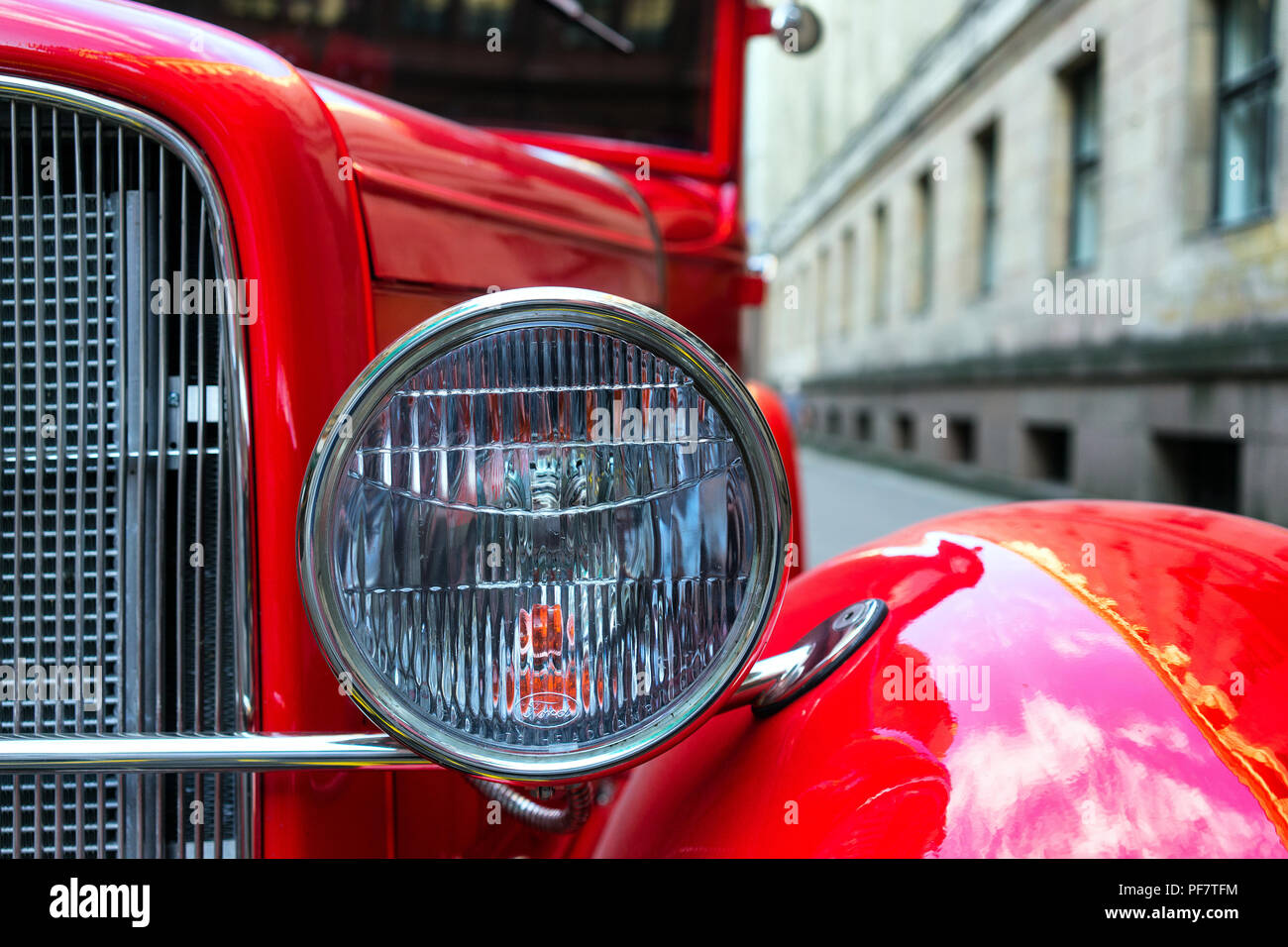 Proiettore di vintage auto rossa su uno sfondo della città vecchia Foto Stock