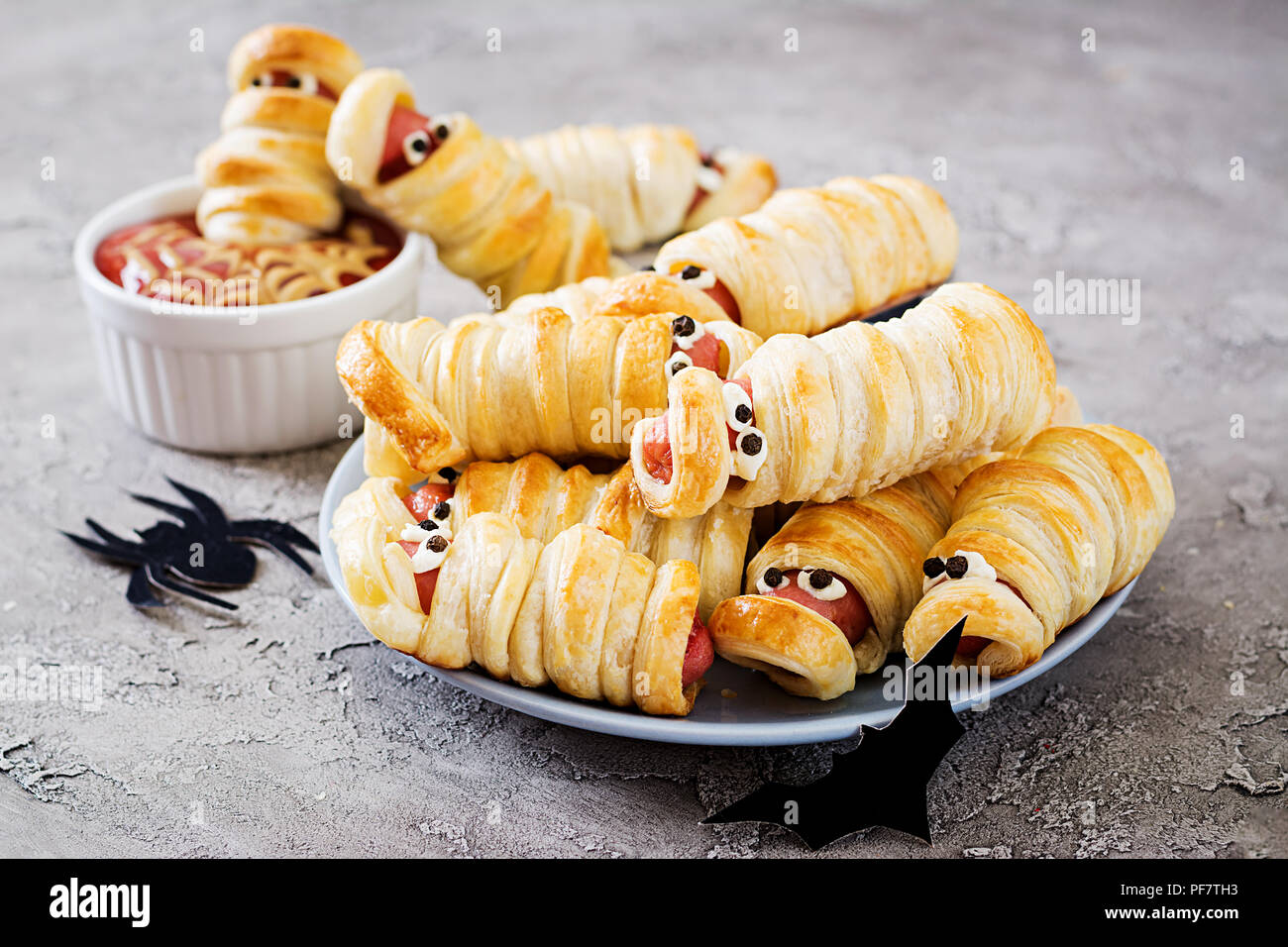 Scary salsiccia mummie in pasta divertente con gli occhi sulla tavola. Divertente decorazione. Cibo di Halloween. Foto Stock