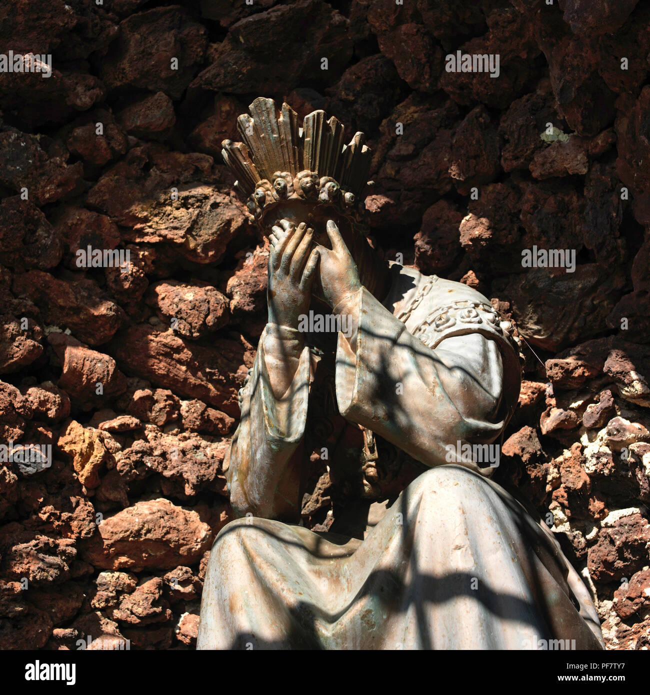 La statua del santo di seduta in una grotta nascondendosi il volto con le mani, Francia Foto Stock