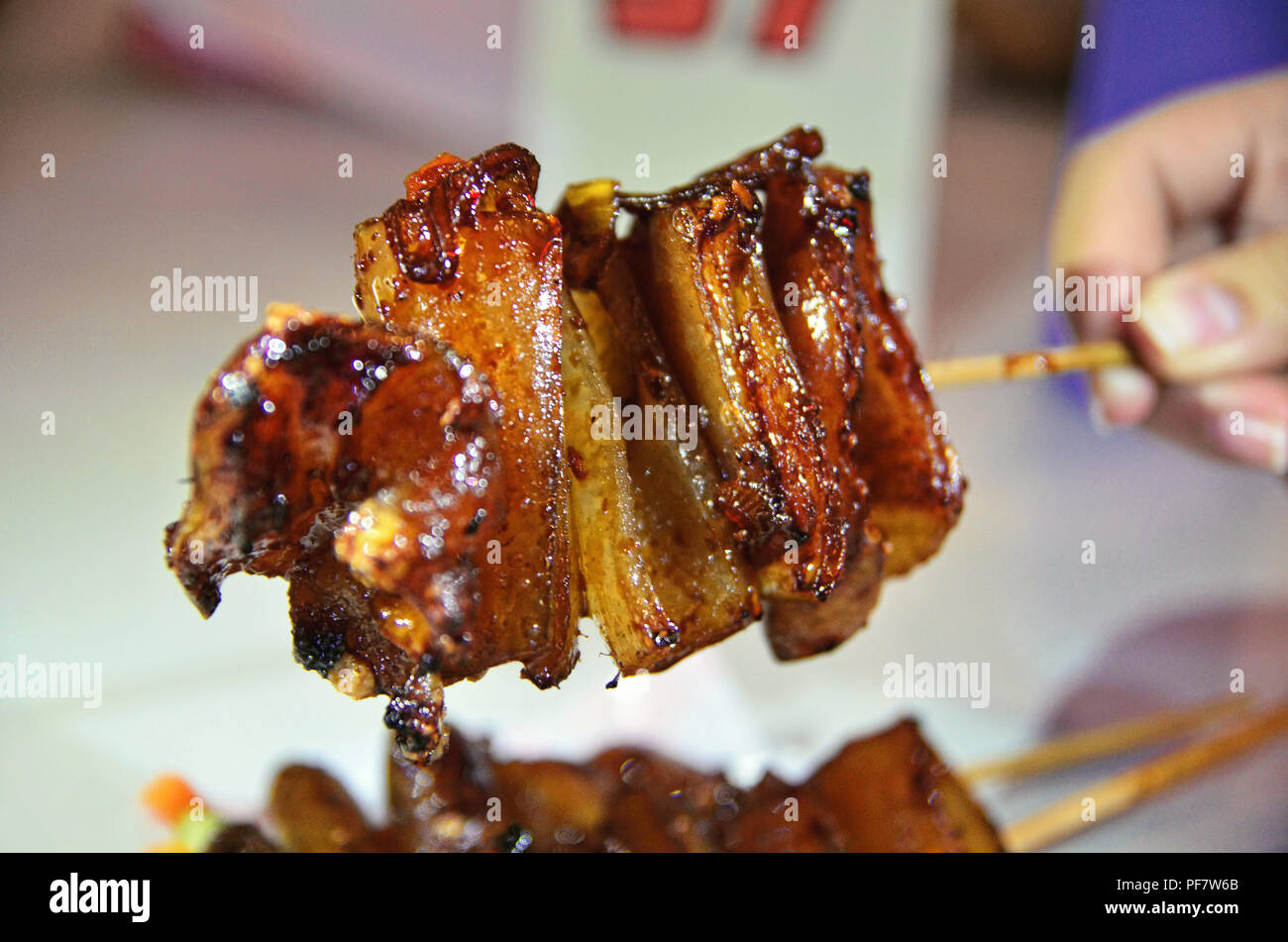 Pelle di maiale satay (kulit sate babi) Foto Stock