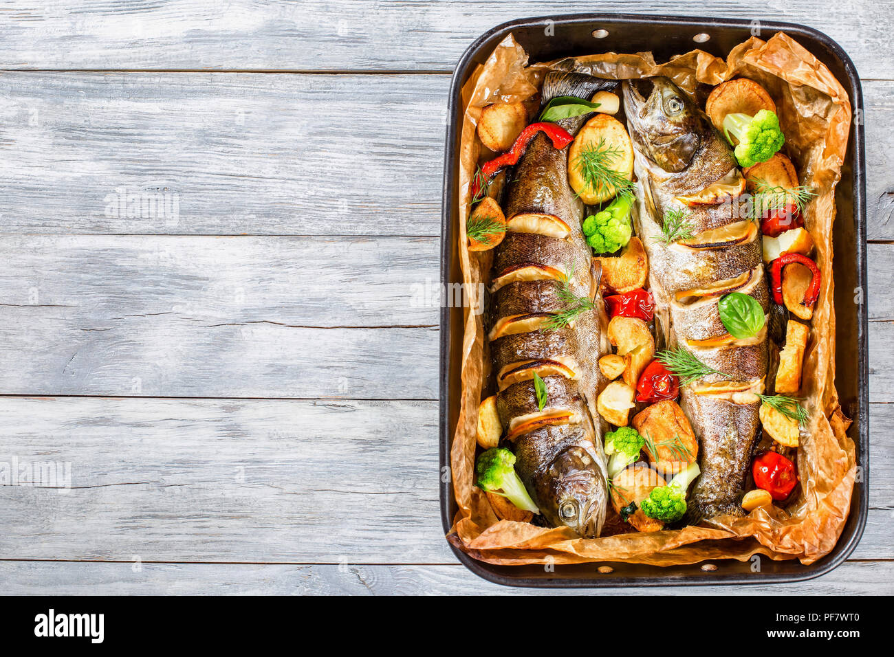 Trota di deliziose grigliate di pesce con patate, broccoli, limone, pomodori, top-view Foto Stock