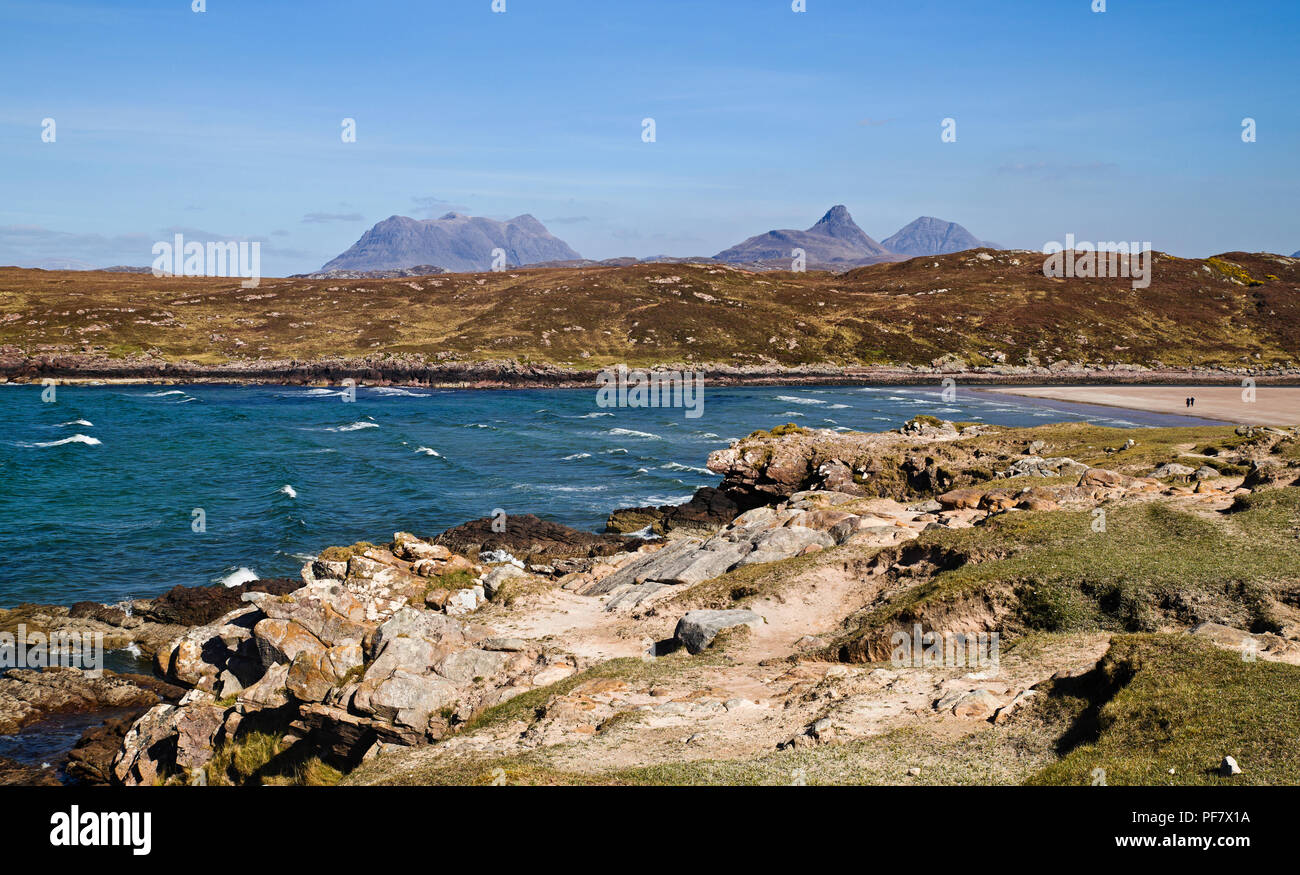 Vista attraverso la rocciosa di foreshore Achnahaird Bay, Coigach, Highlands scozzesi, Inverpolly monti all'orizzonte. Foto Stock