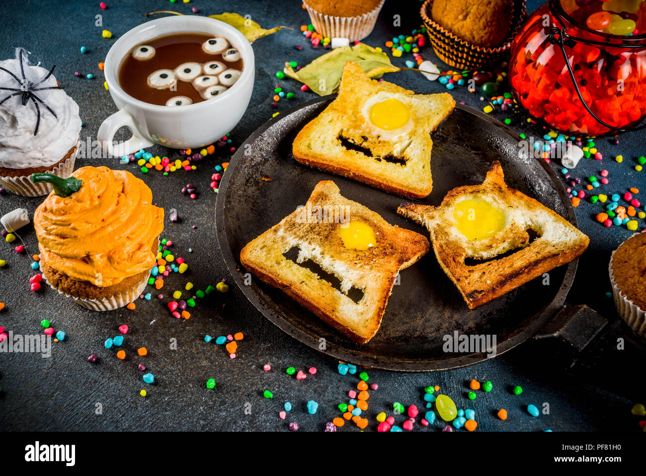Divertente per bambini tratta per la festa di Halloween, un'idea per una festosa colazione. Panini toast con uova, guardando come creepy mostri, cioccolato caldo con m Foto Stock