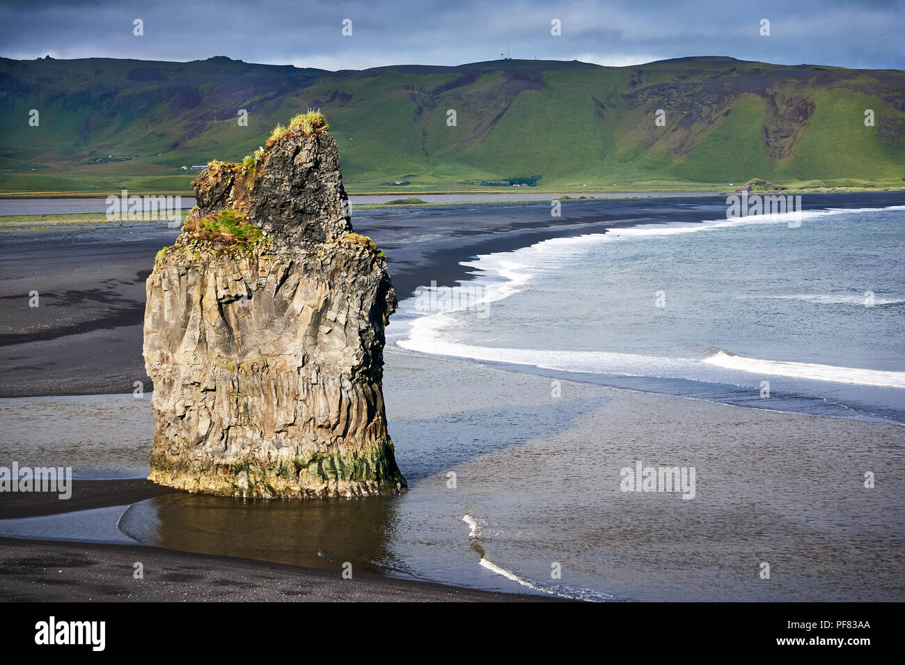 La spiaggia di sabbia nera di Reynisfjara, Vik e il monte Reynisfjall dal promontorio di Dyrholaey e rocce vulcaniche nella costa meridionale dell'Islanda wi Foto Stock