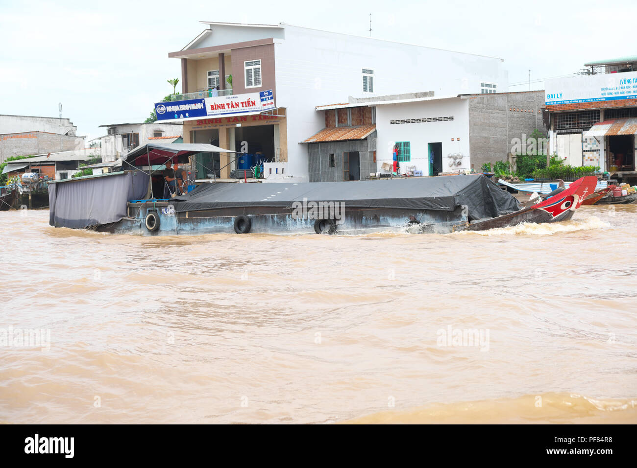 Il Vietnam molto carico cargo viaggi in barca lungo il fiume Mekong nella regione del Delta del Mekong del Viet Nam Foto Stock