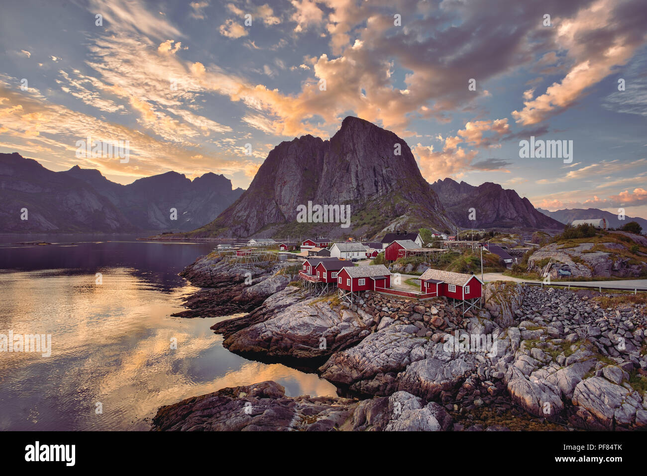 Il rorbu rosso case contro le montagne e golden sunset in Lofoten, Norvegia Foto Stock