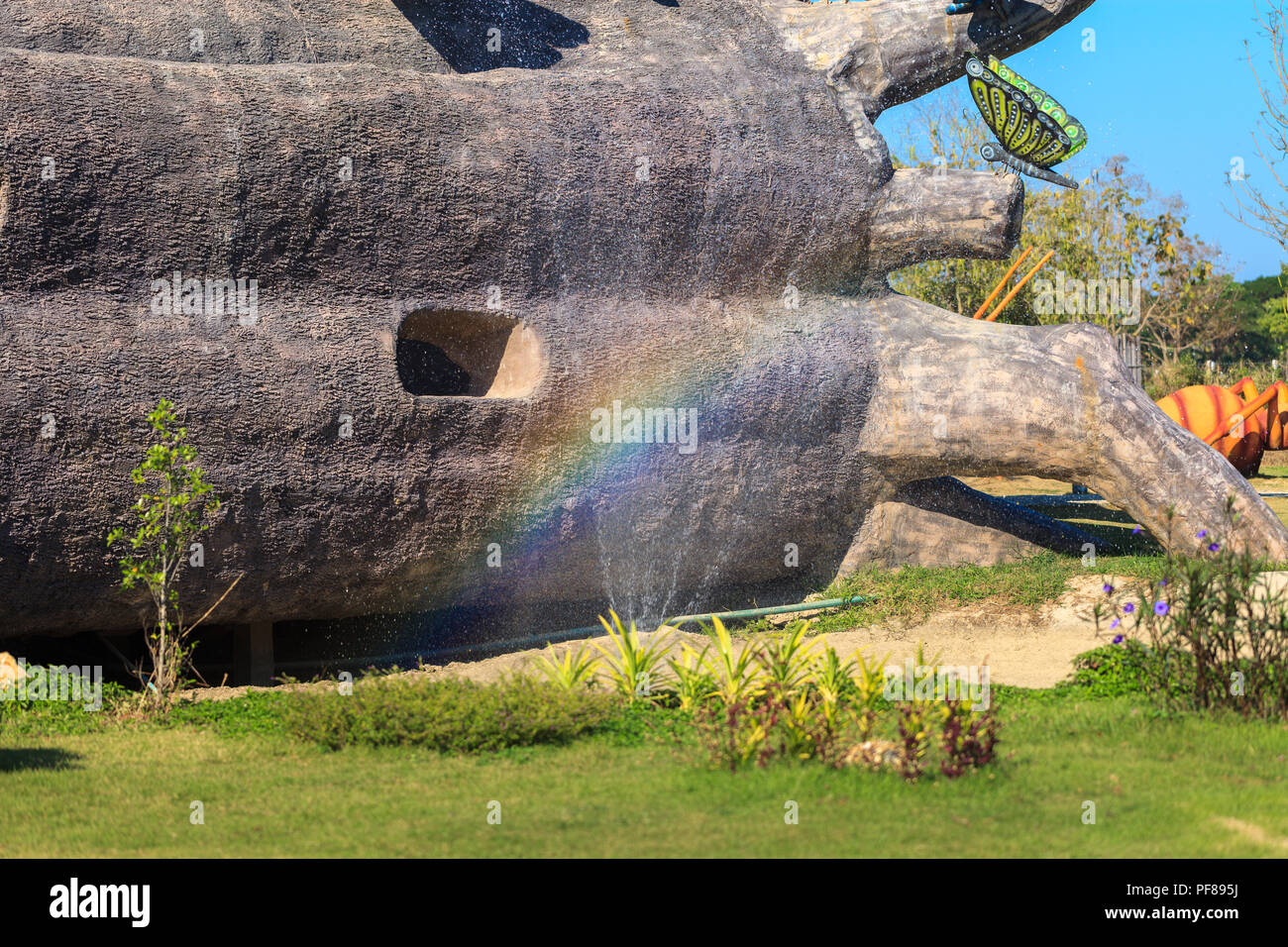 Bellissimo giardino con parco arcobaleno su sfondo sculture nel villaggio nascosto di Chiang Mai, Thailandia Foto Stock