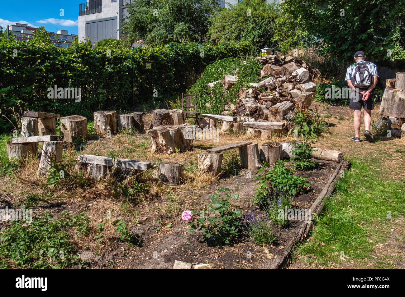 Berlino, Mitte.Niemandsland. Garten, No Mans Land giardino. Circolare posto di incontro con sedie e panche costituito da vecchi log in Chiesa comunità giardino Foto Stock