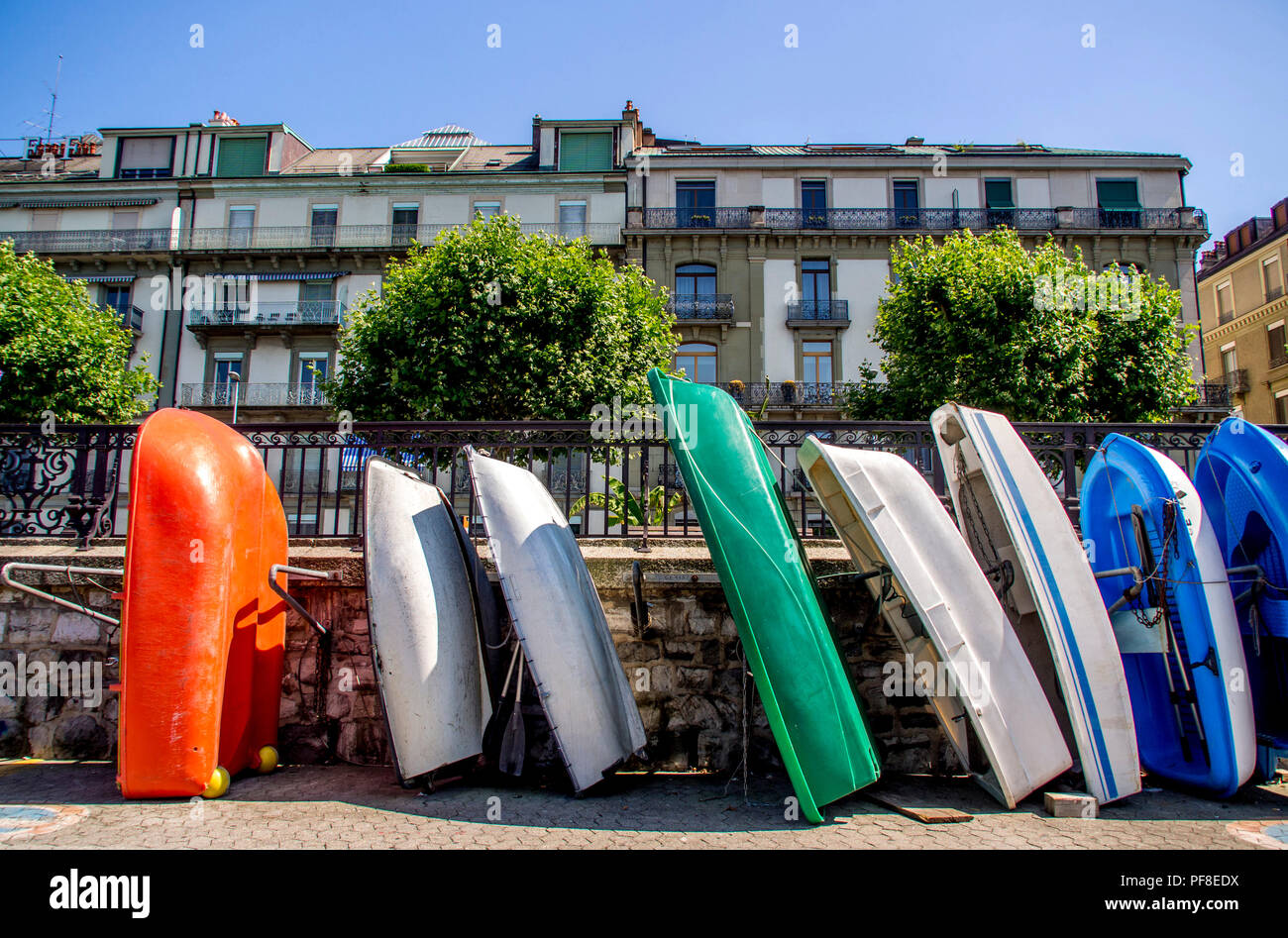 Allineamento del multicolores piccole barche lungo una parete di fronte agli edifici in città di Ginevra. La Svizzera. Europa Foto Stock