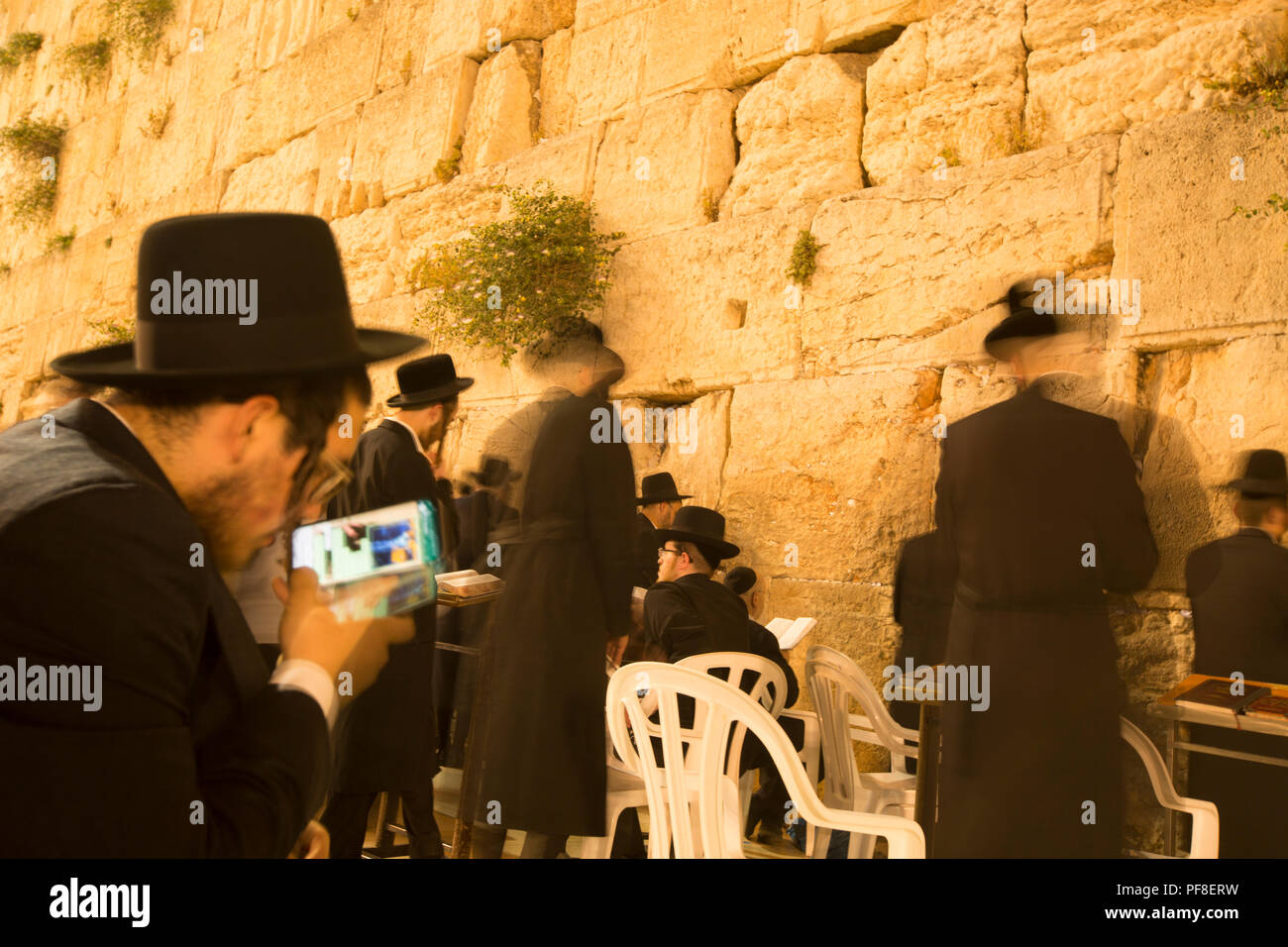 Ebrea ortodossa l uomo nel suo smart phone mentre la preghiera al Muro del Pianto, la Città Vecchia di Gerusalemme Foto Stock