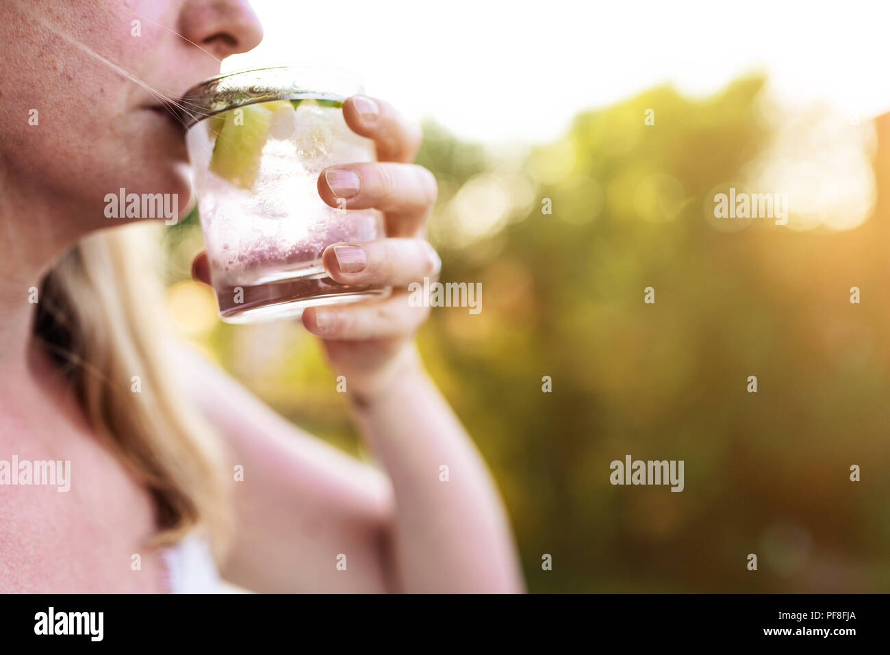 Close-up di donna bionda all'aperto sul giorno di estate bere drink ghiacciato Foto Stock