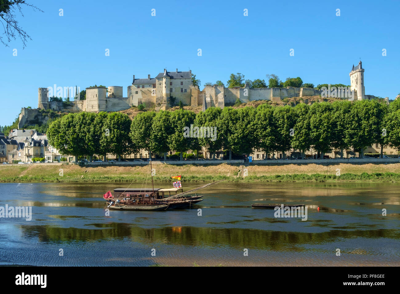 Chinon, Indre-et-Loire, Francia - 26 Giugno 2018: il castello di Chinon sulla collina sopra il fiume Vienne dove tour attendere barche ormeggiate su un soleggiato inizio pomeriggio estivo in Indre-et-Loire, Francia Foto Stock