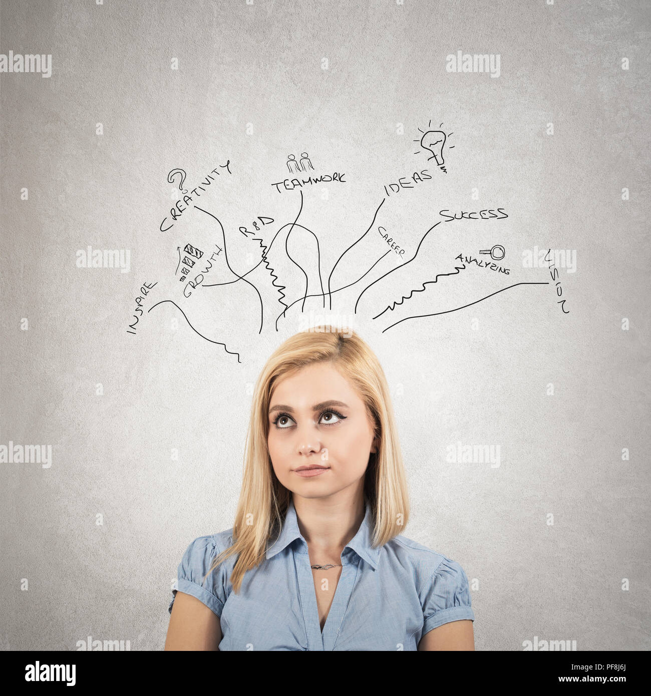 Donna in maglietta blu è in piedi di fronte a Lavagna Grigia con startup schizzo su pensando circa lo sviluppo del business Foto Stock