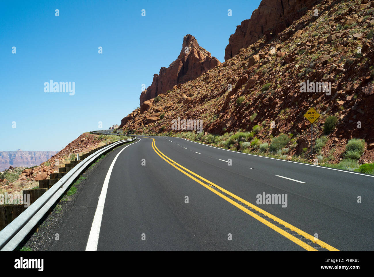 Lonely, Strada Tortuosa Asphalt In Arizona, Stati Uniti Con Due Linee Yellow Center E Rocky Orange Hillside Foto Stock