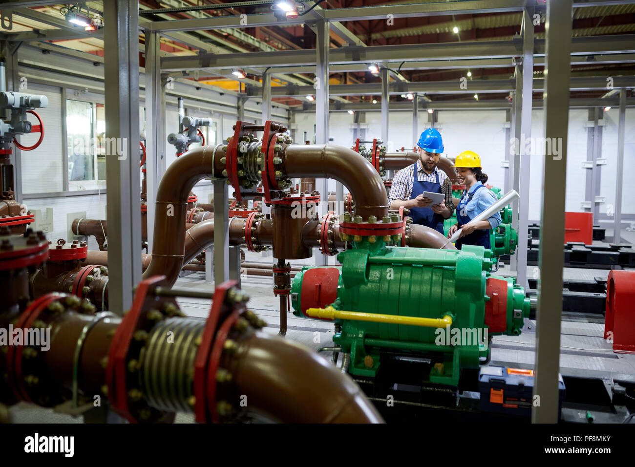 Due lavoratori nel sistema di purificazione di acqua Foto Stock