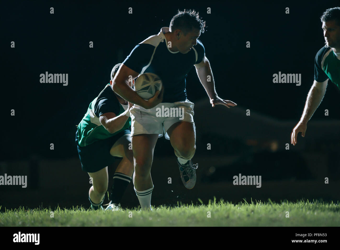 Il Flanker in esecuzione con la sfera e affrontare gli avversari durante il gioco. Partita di rugby in azione. Foto Stock