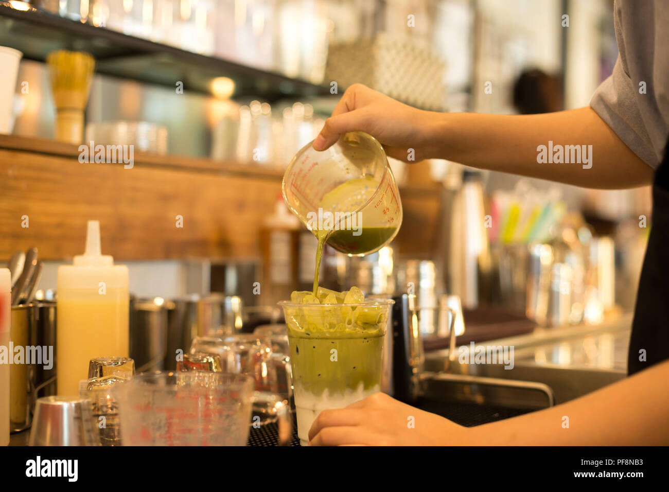 Barista rendendo iced tè verde Matcha latte Foto Stock