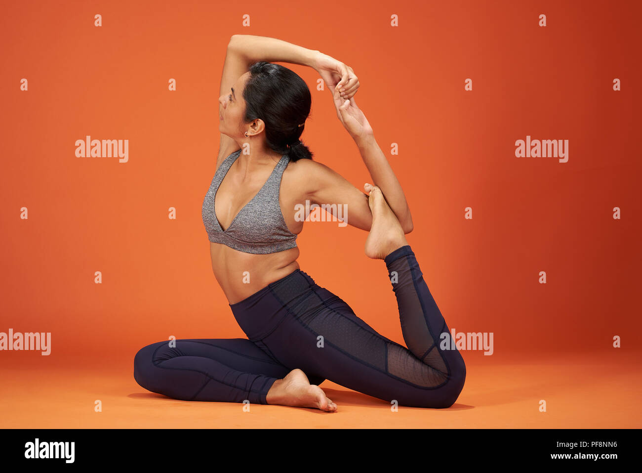 Lo Yoga pone una zampe piccione re mostra giovane donna in studio Foto Stock
