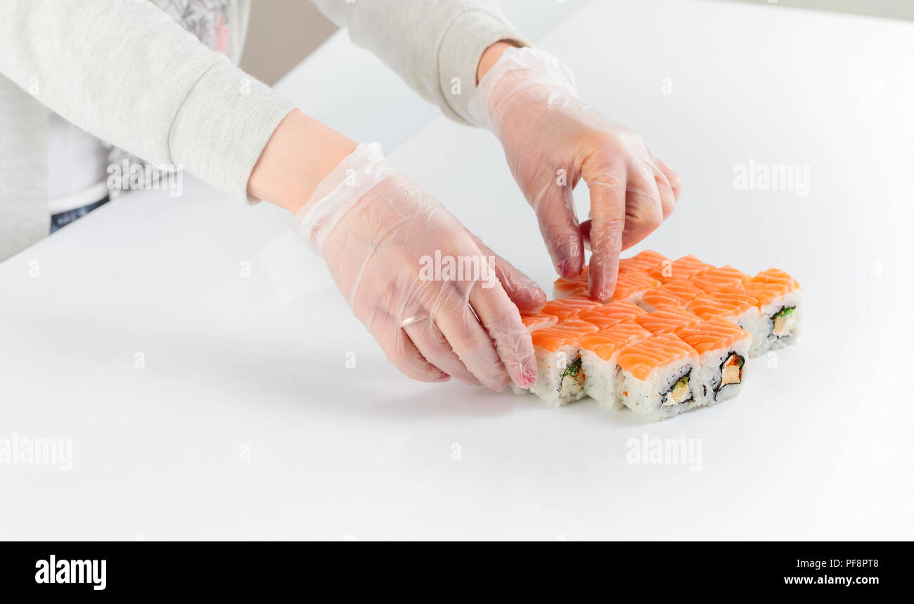 Il personale del ristorante nei guanti di gomma stabilisce la tabella con i frutti di mare. Foto Stock