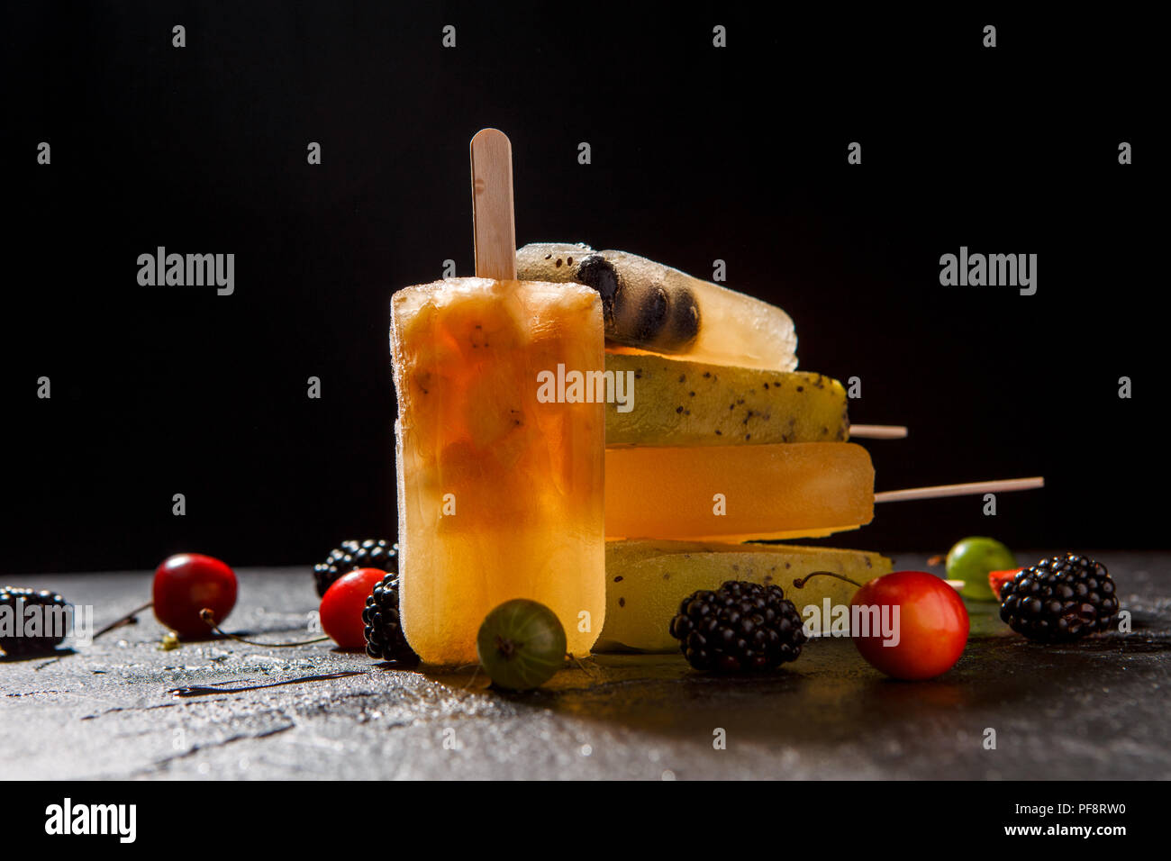 Foto di congelati Succhi di frutta sulla parte superiore di ciascun altro e bacche Foto Stock