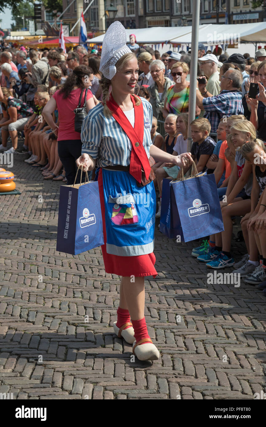 Alkmaar, Paesi Bassi - Luglio 20, 2018: Formaggio girl, kaasmeisje, in costume tradizionale è la vendita di campioni di formaggio al mercato del formaggio di Alkmaar Foto Stock
