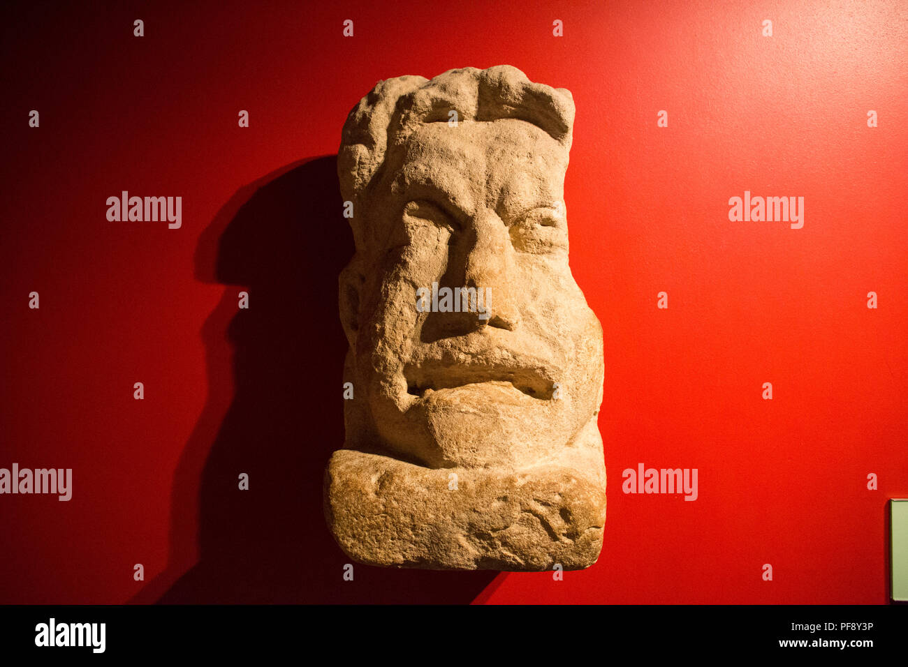 Un Romano maschera teatrale sul display presso le Terme Romane in bagno, Somerset, Inghilterra. Foto Stock